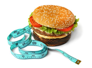 Dieting concept. Tasty hamburger on wooden board and measuring tape on white background