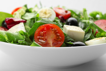 Bowl of fresh mixed salad leaves with tomatoes closeup