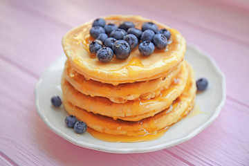 Stack of fresh pancakes with blueberry on wooden background