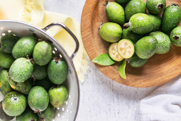 Plenty of feijoa plants on rustic background, in white colander