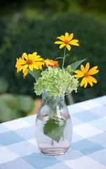 Bouquet of wildflowers on rustic table at country cottage. Picture of beautiful vase with yellow flowers in outdoors.