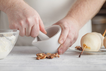 Unrecognizable man chef grinding spices in mortar and pestle to