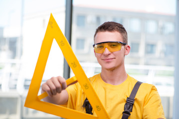 Young construction worker in yellow coveralls