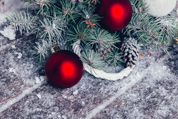 Composition with Christmas decorations in basket, fir tree on wooden background