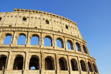 Naklejka premium Close up view of Colosseum in Rome. Monumental 3-tiered Roman amphitheater once used for gladiatorial games, with guided tour option