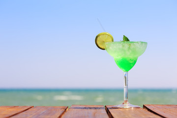 Green fairy cocktail on the wooden pier. Concept of exotic cockt