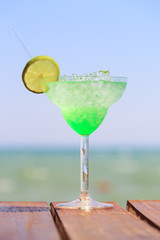 Green fairy cocktail on the wooden pier. Concept of exotic cockt