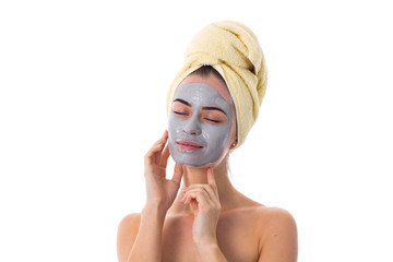 Woman with towel on her head and cosmetic mask on her face 
