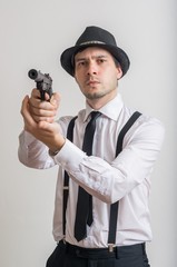 Young detective is aiming with gun with silencer.