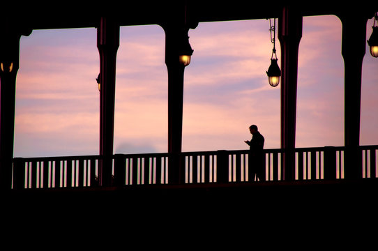 Fototapeta Silhouette of man crossing the bridge