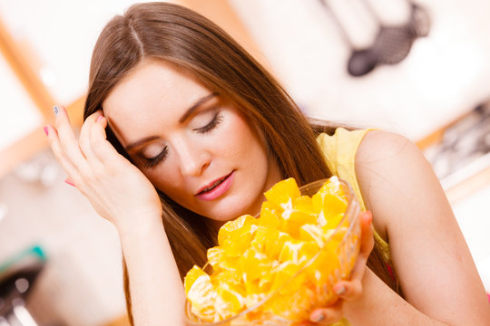 Woman holds bowl full of sliced orange fruits