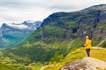 Fototapeta na wymiar Tourist taking photo in norwegian mountains