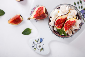 Eton Mess. Fresh figs with whipped cream and meringue in a glass beaker. Dessert.Meringue from egg whites. selective focus