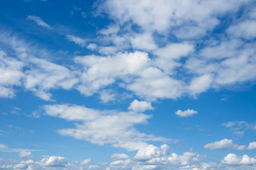 Naklejka na ściany i meble Beautiful coudscape over horizon. White clouds in blue sky.