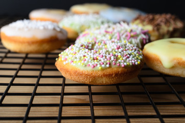 Home Baked Mini Doughnut Cakes with Sprinkles on Cooling Rack