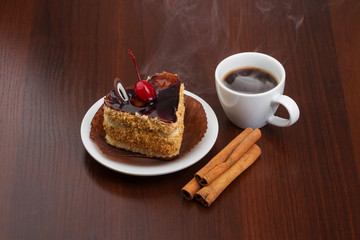 Fototapeta na wymiar Hot coffee with cinnamon sticks and cake on a plate