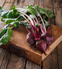 Young,fresh beets with tops on old wooden background.Toned image.Vintage style.selective focus.