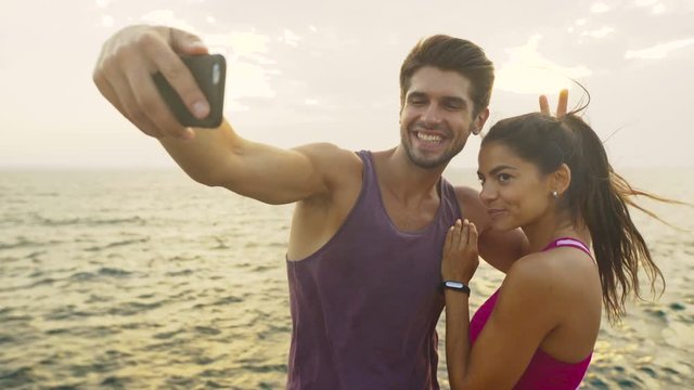 Two young people taking selfies after morning jog.