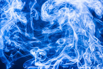 Artistic blue smoke on black background texture.