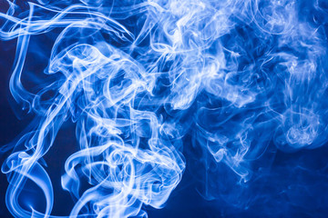 Blue smoke on black background texture.