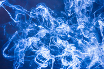 Artistic blue smoke on black background texture.