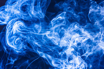 Blue smoke on black background texture.