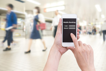Hand holding mobile phone with Mobile banking application with blur crowd people background