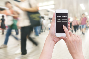 Hand holding mobile phone with Mobile banking application with blur crowd people background