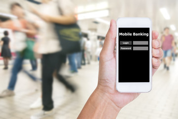Hand holding mobile phone with Mobile banking application with blur crowd people background