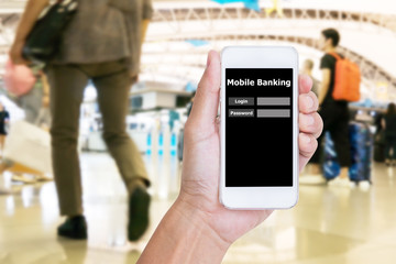 Hand holding mobile phone with Mobile banking application with blur crowd people background