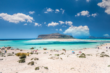 Balos lagoon on Crete island, Greece. Tourists relax and bath in crystal clear water of Balos beach.