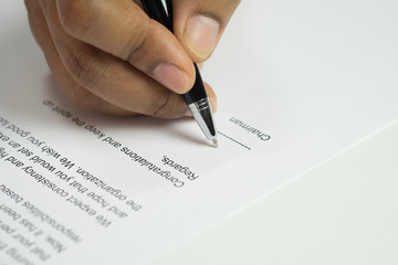 Hand signing a letter on congratulation document