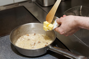 Chef is putting butter to risotto