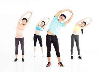Fototapeta na wymiar smiling young fit group stretching in gym