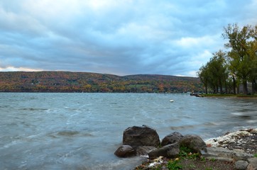 Fototapeta na wymiar waves crashing on the shore of Canandaigua Lake on a cloudy Autumn day
