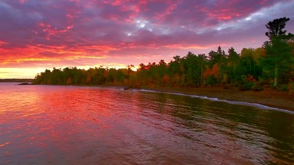 Dramatic red dawn over Fall colors in Copper Harbor Michigan, moving aerial view.
 - Powered by Adobe