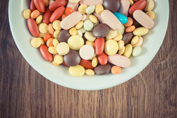 Vintage photo, Colorful medical pills, tablets and capsules on plate, health care concept