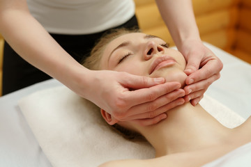 Fototapeta na wymiar Spa. Massage therapist massaging client's chin