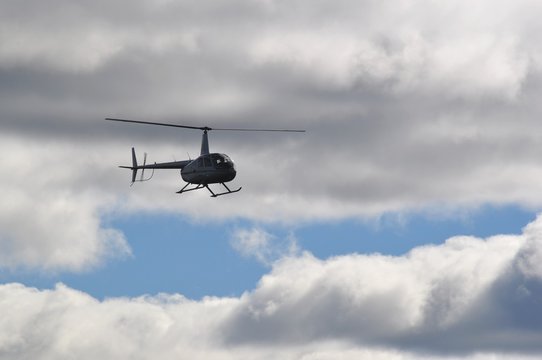 Flying helicopter in the cloudy sky