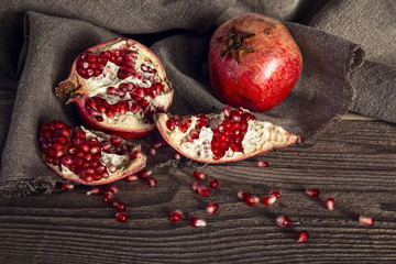 Still life with fresh juicy pomegranate on sackcloth on on rusti