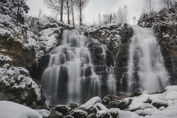 beautiful winter waterfall in winter forest