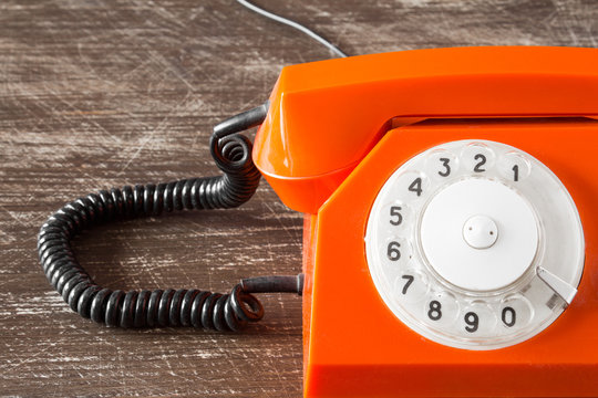 Close up view of part of old orange telephone