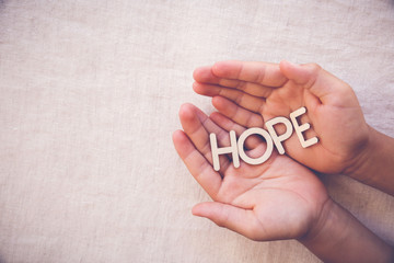 Obraz premium HOPE wooden word on praying hands , gratitude, faith concept