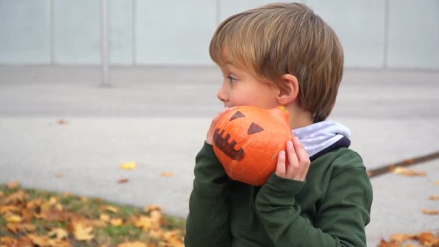 junger bub spielt mit k&uuml;rbis zu halloween