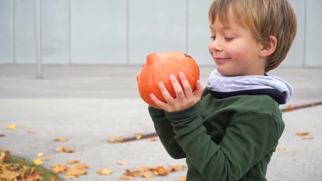 junger bub spielt mit k&uuml;rbis zu halloween