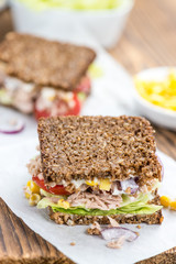 Wooden table with Tuna sandwich (on wholemeal bread; selective f