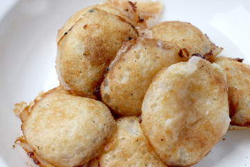 Kind of Thai sweetmeat , thai dessert, Thai coconut pudding. Kanom Krok stuffed with corn on cutting board with wooden table.