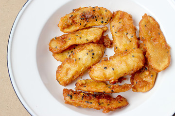 Fried Bananas sprinkled sesame tasty traditional food in white dish on wood table background. - Thai Snack