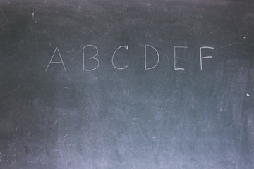 Blackboard with the first letters of the alphabet written on it