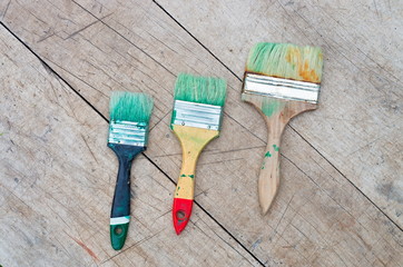 brush in green paint on a wooden background